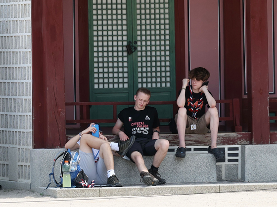 British scouts sit in the shade of a pavilion inside Gyeongbok Palace in central Seoul on Monday. The British contingent was the first to announce its departure from the World Scout Jamboree campsite in Buan County, North Jeolla. [YONHAP]